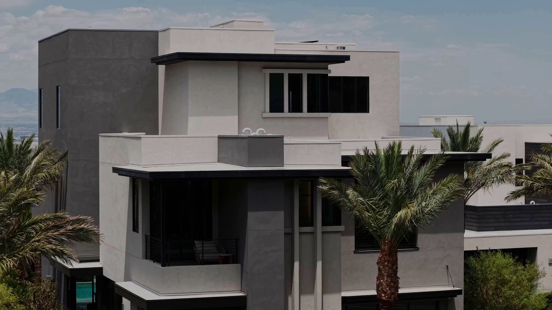 Modern Las Vegas home exterior with palm trees and mountain views