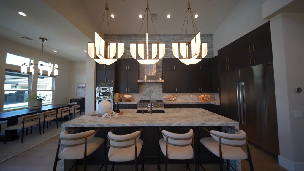Kitchen with a marble island and pendant lights in a single-story Las Vegas luxury home